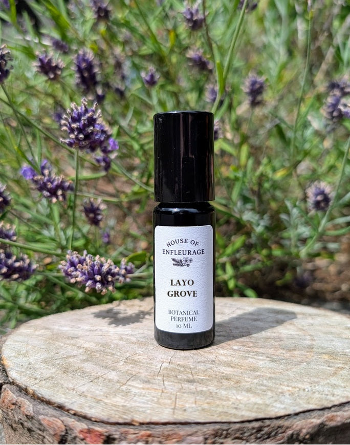 Bottle of Layo Grove botanical perfume on a wooden stump with lavender in the background